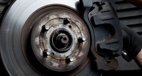 a mechanic changing out brake pads on a vehicle