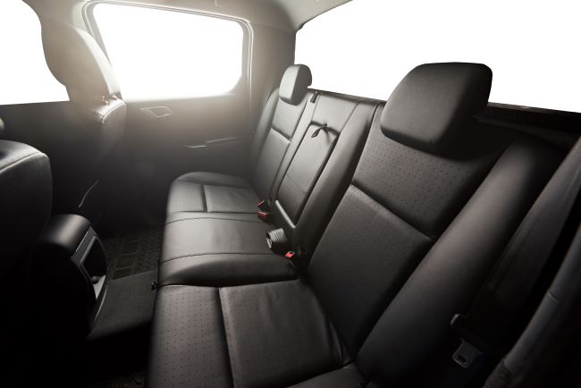interior of pickup truck in black with three seats and red buckles
